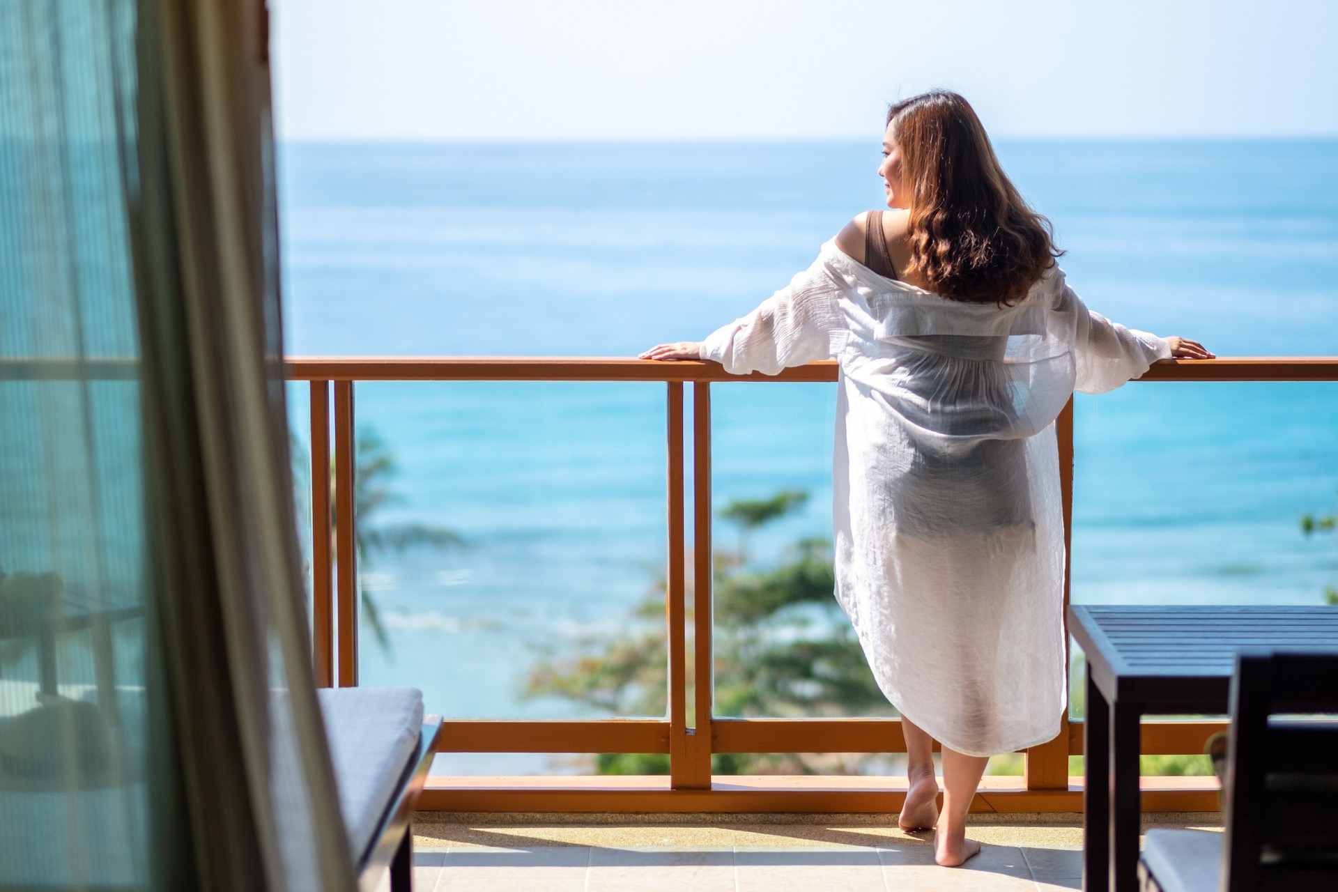 woman standing and enjoy watching the sea view at balcony